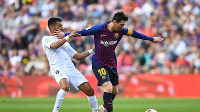 Lionel Messi holds off a challenge from Angel Gavilan. Getty Images