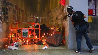 An anti-government protester at a burning barricade on during a Global Anti-Totalitarianism Rally in Hong Kong. EPA