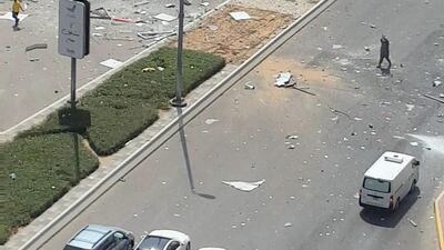 The accident left debris strewn across the street in front of the building.