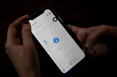 A woman uses her mobile phone to check Facebook in Yangon on February 4,2021 as Myanmar's generals ordered internet providers to restrict access to Facebook, days after they seized power. AFP