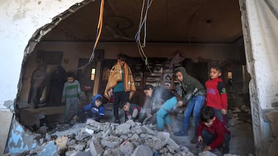 Palestinian children sift through debris following an Israeli attack in Rafah in the southern Gaza Strip. AFP