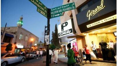 A signpost points to Rainbow Street, famous as a party zone but also home to Jordan's Royal Film Commission. Below, Books@Café is one of Amman's favourite night spots. Salah Malkawi for The National