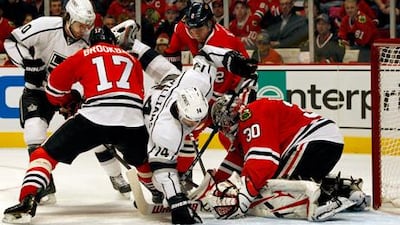 Chicago Blackhawks goalie Ray Emery looks to block Los Angeles' Justin Williams during a goalmouth melee.