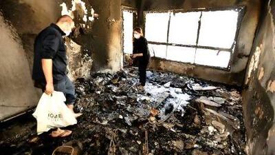 Ehab Emad and his wife Esra look through what is left of their living room to see if anything can be salvaged from the fire that damaged their 5th floor apartment. Charles Crowell for The National