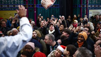 A butcher throws a cut of meat to a bidder during the traditional Christmas Eve meat auction at Smithfield Market in the City of London. AFP