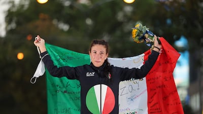 First-placed Italy's Antonella Palmisano celebrates on the podium during the medal ceremony after competing in the women's 20km race walk.