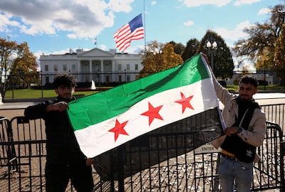 People hold a Syrian flag outside the White House after a meeting between Donald Trump and Ahmad Al Shara in November 2025. Reuters