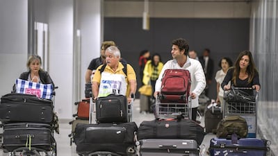 Passengers arriving from the US walk with their baggage through Terminal 3 of the Guarulhos International Airport in Guarulhos, Brazil. Paulo Fridman / Bloomberg