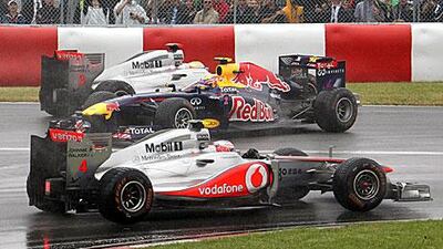 Red Bull's Webber, centre, and Hamilton collide in the Senna corner as Button drives.