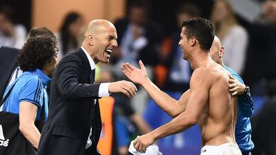 Real Madrid manager Zinedine Zidane, left, celebrates with forward Cristiano Ronaldo after Real Madrid won the Uefa Champions League final over Atletico Madrid at San Siro Stadium in Milan, on May 28, 2016. AFP / FILIPPO MONTEFORTE