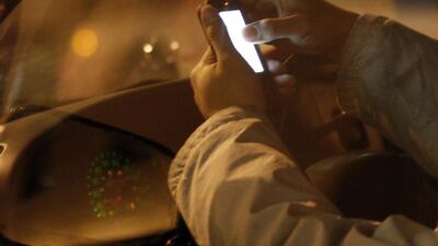 A driver checks his phone while sitting in a car in New York City. Jessica Rinaldi / Reuters