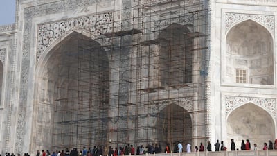 This photograph taken on January 3, 2018 shows tourists visiting the Taj Mahal near scaffolding installed for the conservation work at the monument in the Indian city of Agra. Restoration work at India's most popular tourist attraction has been dragging on for years, blighting views for tourists. Dominique Faget /AFP Photo