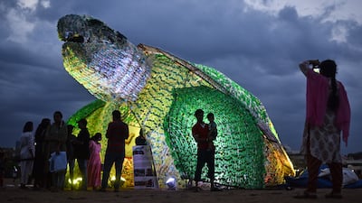 People stand near a huge replica of the green sea turtle made up of used plastic bottles to raise awareness among the public against the use of single-use plastic and its effect on marine life, at Edward Elliot's Beach in Chennai, India, 24 June 2023. The green sea turtle model made up of 600 kilograms of used plastic bottles was installed by Walk For Plastic (WFP), an environmental conservation organization, to create awareness among the public about plastic pollution's effect on marine life and to minimize the use of single-use plastic at Edward Elliot's Beach. EPA / IDREES MOHAMMED