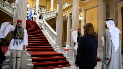 President Sheikh Mohamed and Ms Katerina Sakellaropoulou stand for the UAE and Greek national anthems.