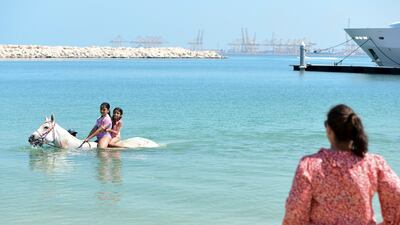 Coetzee watches on as children enjoy swimming with the horses