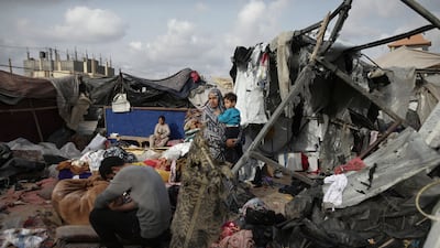 Palestinians sit among the remains of their tents after Israeli bombardment close to an UNRWA centre in the west of Rafah city on May 28. AP