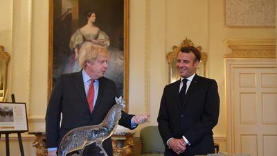 British Prime Minister Boris Johnson and French President Emmanuel Macron look at documents and artifacts related to former French president Charles de Gaulle, including a Cross of Lorraine, right, given as part of the Order de la Liberation to Winston Churchill in 1958, and a Lalique cockerel, left, given by de Gaulle to Clementine Churchill during the Second World War, at 10 Downing Street. Getty Images
