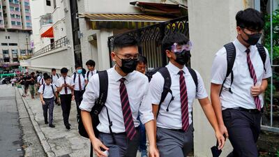 Students wearing masks, walk along with their formal uniforms near Diocesan Boys' School in Hong Kong. AP Photo