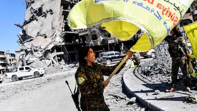 Rojda Felat, a Syrian Democratic Forces (SDF) commander, waves the alliance's flag in Raqqa's Al Naim square on October 17, 2017. Bulent Kilic / AFP