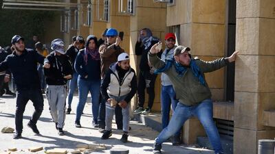 Anti-government protesters throw stones at the riot police during a protest in downtown Beirut. AP Photo