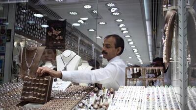 Dubai, United Arab Emirates - January 07 2013 - A salesman at the Gold Souk in Deira shows a display board of gold rings to a customer. Unlike the malls, the Gold Souk is still a popular place to buy and sell gold for many tourists and residents of Dubai. (Razan Alzayani / The National)