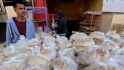 An Egyptian baker waits for customers with plastic bags of bread in Cairo. Reuters
