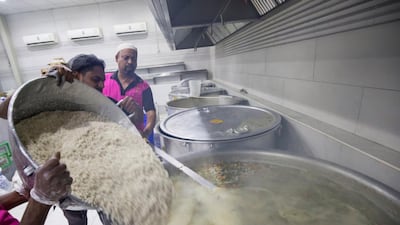 Cooks add broken rice to the broth to make a nutritious porridge that they will serve to thousands of people breaking their fasts in Deira. All photos: Leslie Pableo for The National
