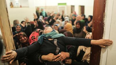A Palestinian relative of Hamdan Abu Amsha, who was killed a day earlier by Israeli forces when clashes erupted as tens of thousands as Gazans marched near the Israeli border with the enclave to mark Land Day, cry during his funeral in Beit Hanun in the northern of Gaza Strip on March 31, 2018. Mahmud Hams / AFP