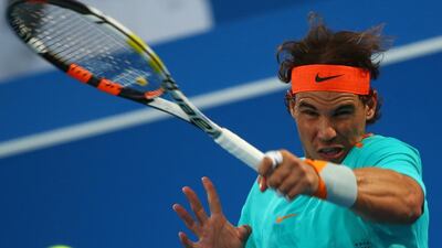 Spanish tennis player Rafael Nadal returns the ball to Stanislas Wawrinka of Switzerland during their consolation match in the Mubadala World Tennis Championship in Abu Dhabi on January 3, 2015. AFP PHOTO/MARWAN NAAMANI