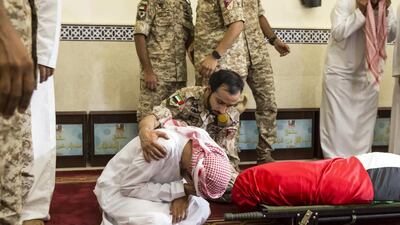 A mourner is comforted during the funeral service in Dubai for Saif Al Falasi. Antonie Robertson / The National
