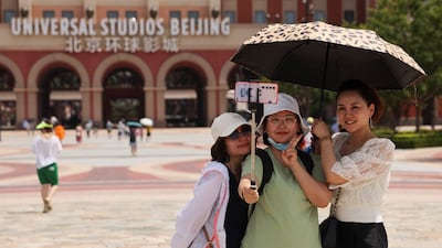 Tourists take selfies in front of the Universal Studios theme park in Beijing, China. Reuters
