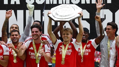 Arsenal captain Martin Odegaard lifts the trophy as he celebrates with teammates after winning the FA Community Shield. Reuters