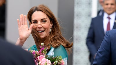 Britain's Catherine, Duchess of Cambridge gestures to the crowd as she leaves the Aga Khan Centre in London. AFP