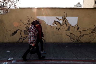 Iranians walk past a mural depicting the epic poem Shahnameh, in Tehran. AFP