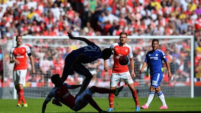 Arsenal’s German midfielder Mesut Ozil (2nd L) vies with Chelsea’s Serbian midfielder Nemanja Matic in the shadows during the FA Community Shield football match between Arsenal and Chelsea at Wembley Stadium in north London on August 2, 2015. Arsenal won the game 1-0. AFP PHOTO / GLYN KIRK