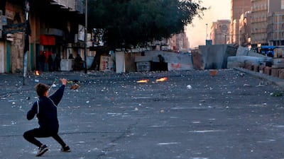 An anti-government protester uses a slingshot to fire a stone at security forces during clashes near Khilani Square in Baghdad. AP Photo