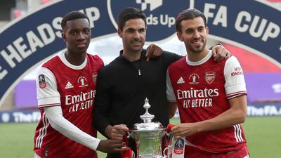Arsenal's head coach Mikel Arteta poses with Dani Ceballos, right, and Eddie Nketiah. AP