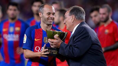 A relative of Barcelona's founder Joan Gamper gives the trophy to Barcelona midfielder Andres Iniesta after their win in the annual 51st Joan Gamper Trophy match between FC Barcelona and UC Sampdoria at the Camp Nou stadium in Barcelona on August 10, 2016. Josep Lago / AFP