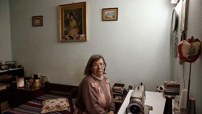 Chrysoula Charizanou, 76, a Greek owner of an apartment, poses inside her bedroom.
