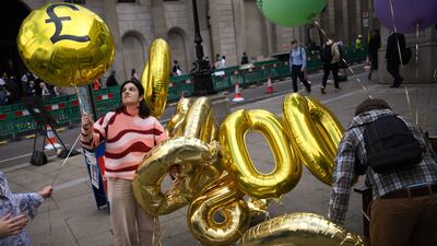 Protesters with balloons and placards representing the billions of pounds of profit earned by British banks. AFP
