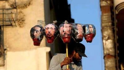 A protester carries symbolic heads of the ousted president, Hosni Mubarak, centre, and from left, his son Alaa, his interior minister Habib Al Adly, wife Suzanne and son Gamal, during a rally in Tahrir Square, Cairo, on Tuesday in protest at the outcome of the Mubarak trial.
