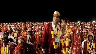A bride and groom stand during a mass wedding ceremony of more than 100 couples in Virar, on the outskirts of Mumbai, India on January 29.