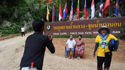 Visitors posing for photos near the entrance of the Tham Luang cave. AFP