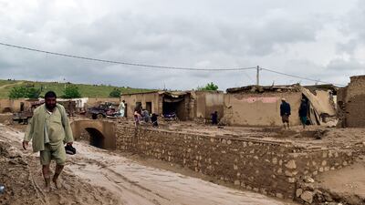 People clean up their damaged homes in Baghlan province. AP