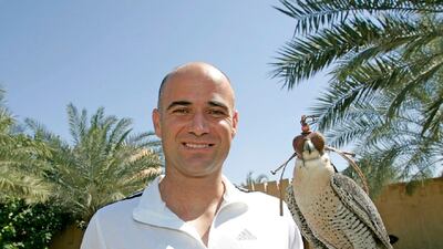 American tennis player Andre Agassi poses for a picture with three-year-old female Peregrine falcon named DJ in Dubai 27 February 2006. AFP