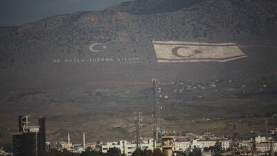 A giant Turkish Cypriot flag is embossed on a mountain overlooking Nicosia and southern Cyprus. The words next to it read 'How happy is the one who says "I am a Turk"'. Josh Wood for The National