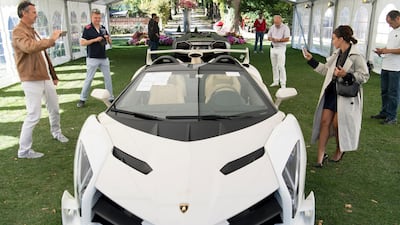 People look at a 2014 Lamborghini Veneno Roadster, part of some 25 luxury cars owned by the son of the Equatorial Guinea's President Teodoro Obiang that were seized in a money-laundering probe. Laurent Gillieron/Keystone via AP