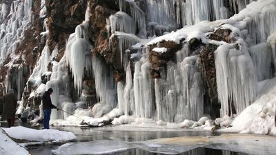 A Kashmiri man fishes near a frozen waterfall in the Drang area of Tangmarg, north of Srinagar, the summer capital of Indian Kashmir. EPA