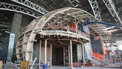 Workers operate from an aerial platform near the passenger departures hall entrance at the Midfield Terminal. Natalie Naccache / Bloomberg