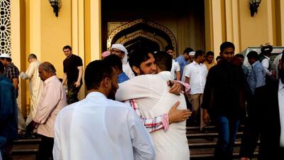 Men greet each other after taking part in Eid prayers at Musaab Bin Omair Mosque in Abu Dhabi. Christopher Pike / The National